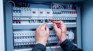 An electrician conducting an electrical safety check testing a safety switch